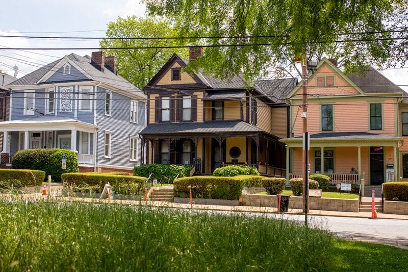 A row of victorian houses on a street.