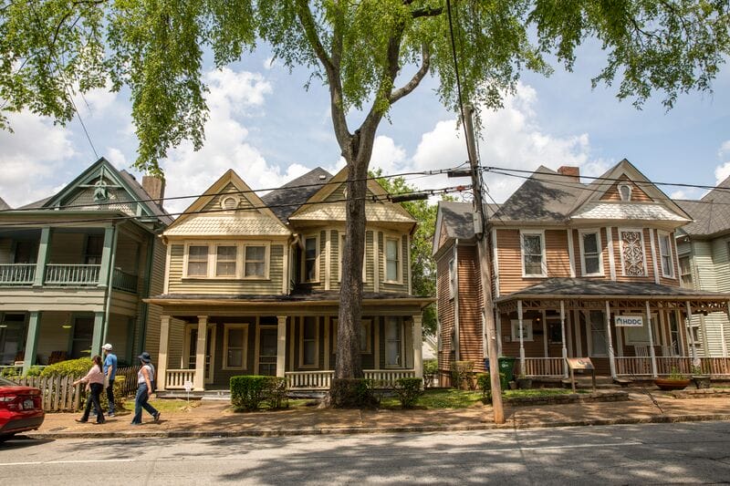 A row of victorian homes on a street.