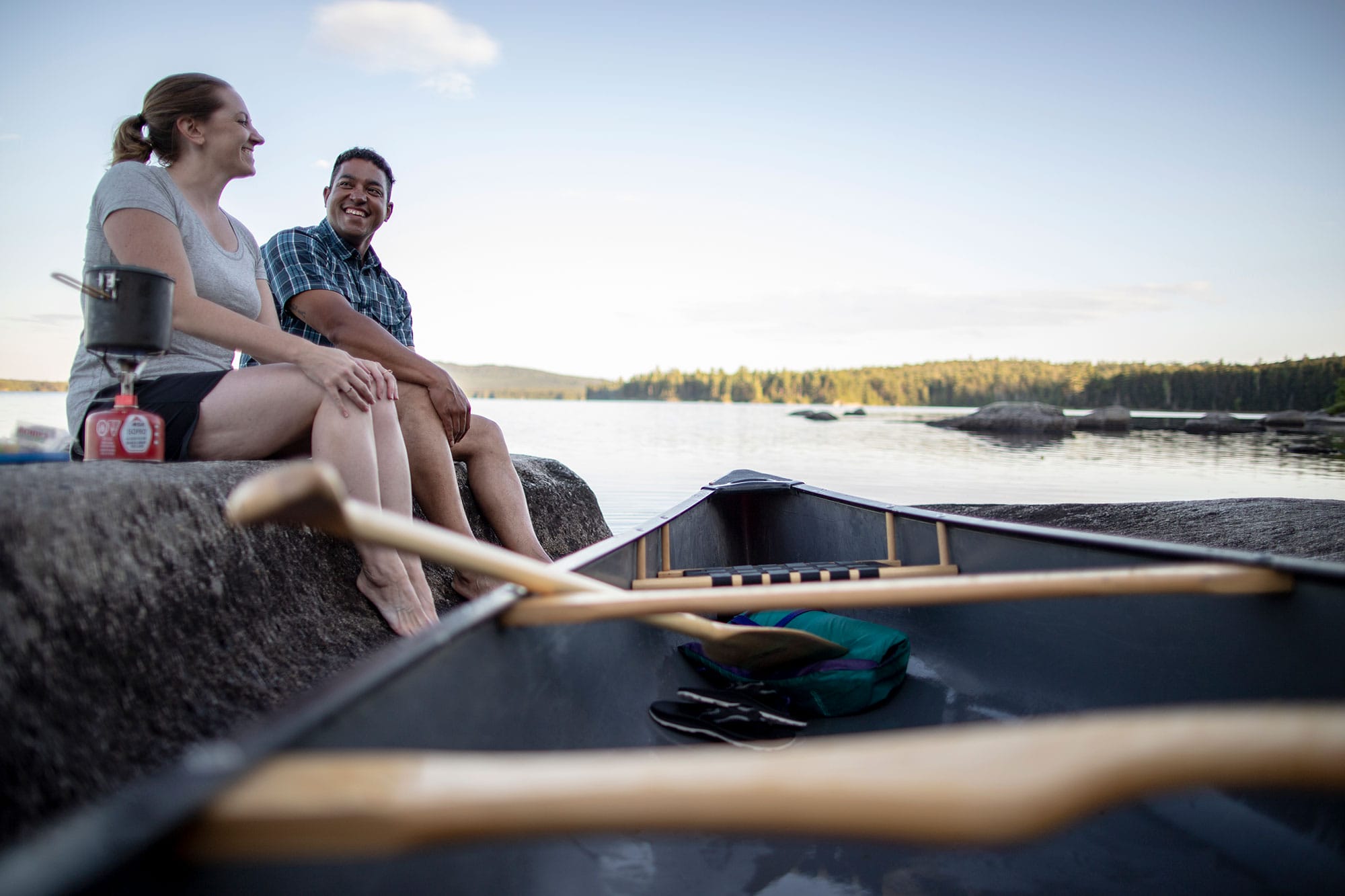 A man and woman sitting in a canoe on a lake.