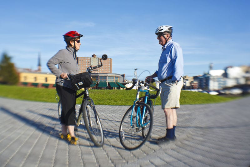 A man and a woman standing next to their bicycles.
