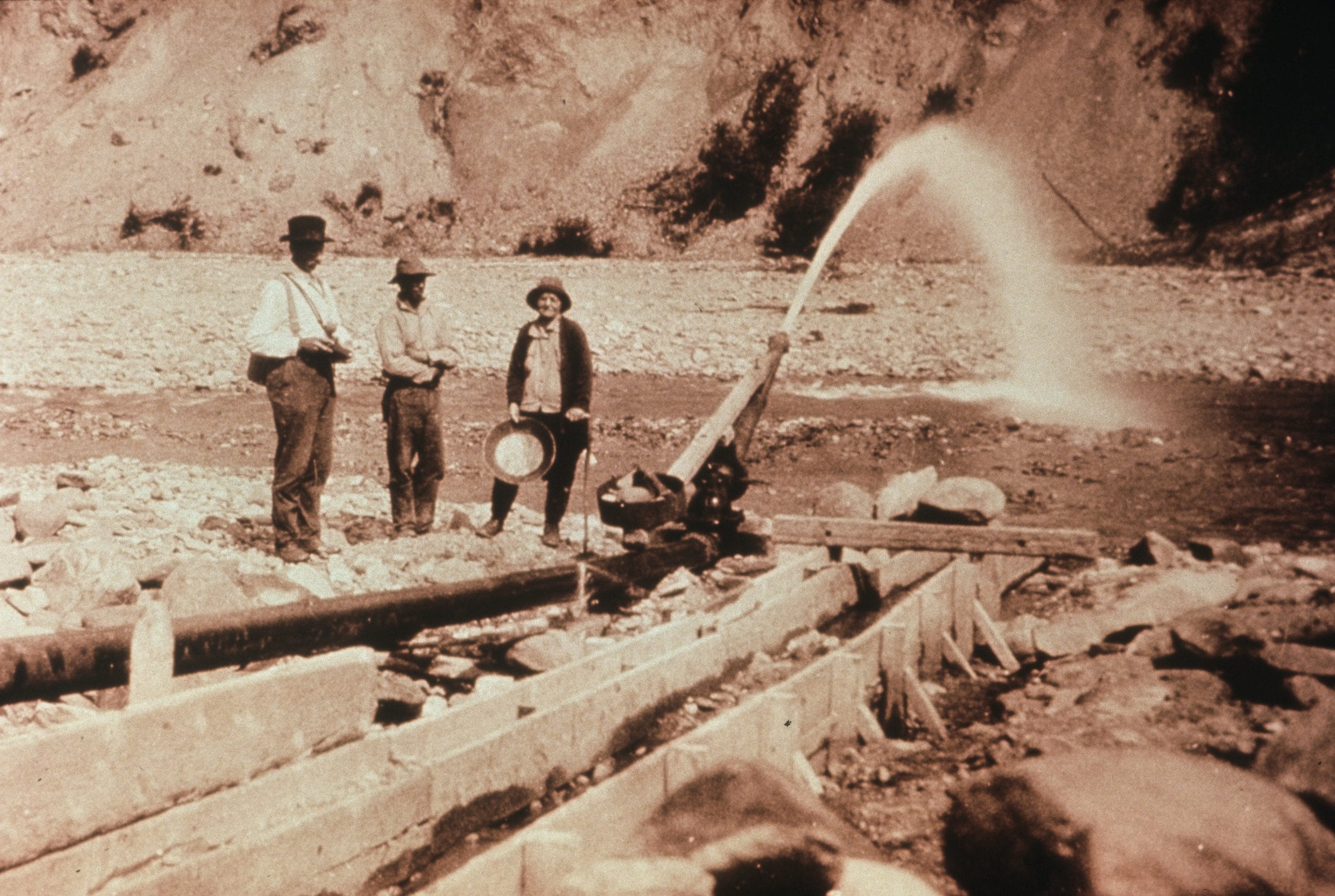 A group of men standing next to a water pipe.