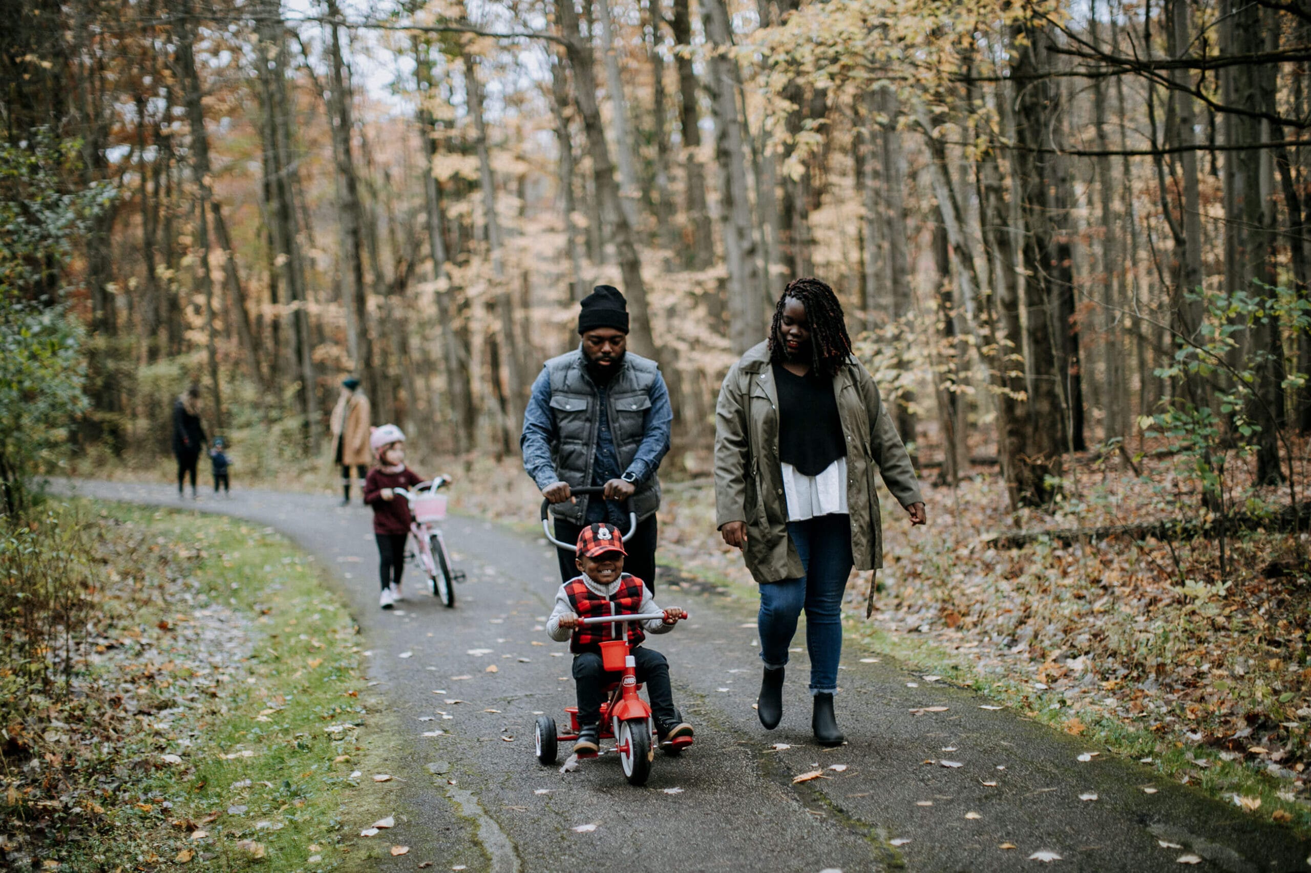 A family walks down a path in the woods.