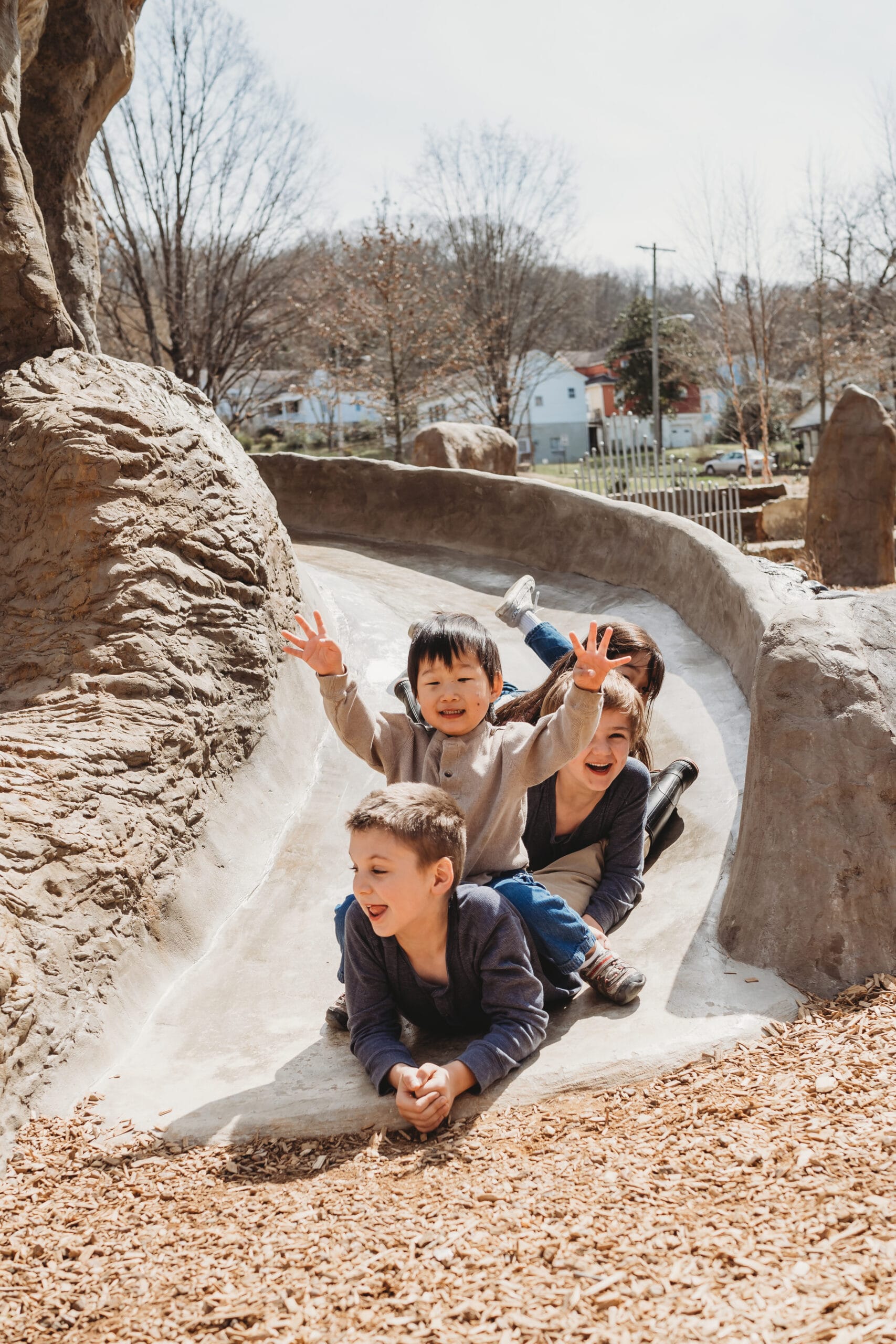 A group of children playing on a slide at a zoo.