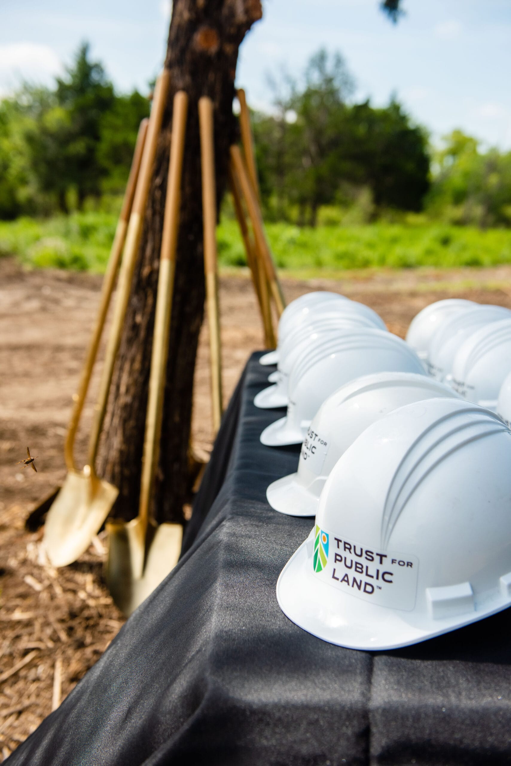 A group of hard hats and shovels on a table.