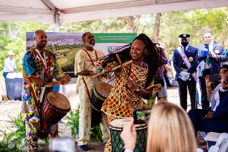 A group of people playing drums in front of a crowd.