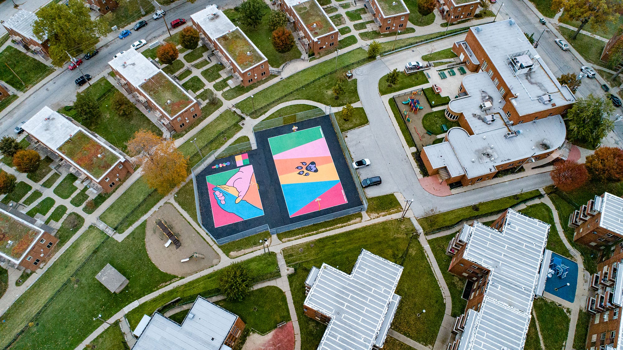 An aerial view of a colorful building in the middle of a city.