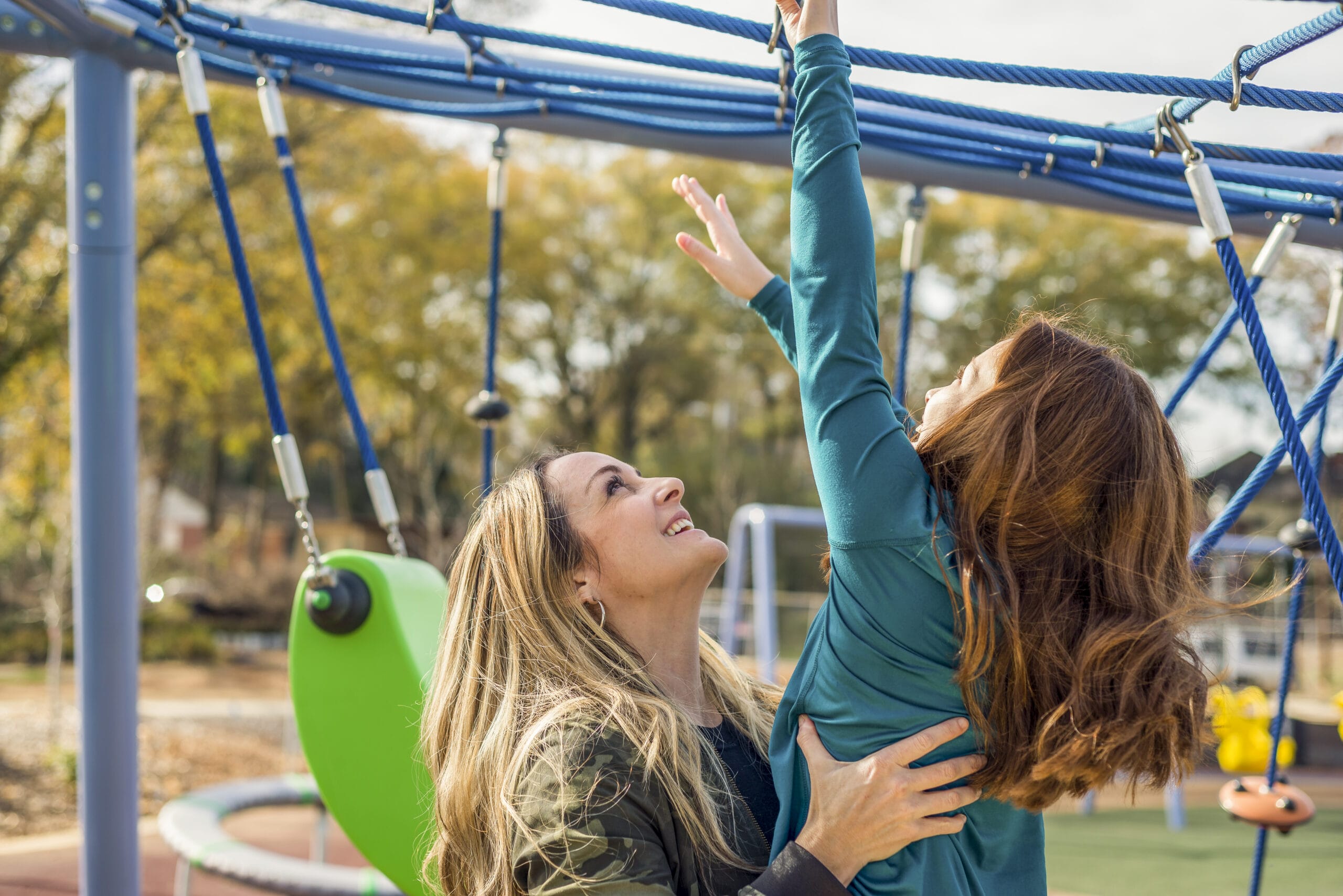 Two women playing on a playground.
