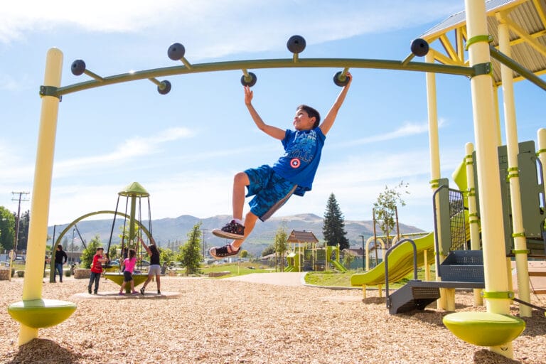 A boy is playing on a playground.