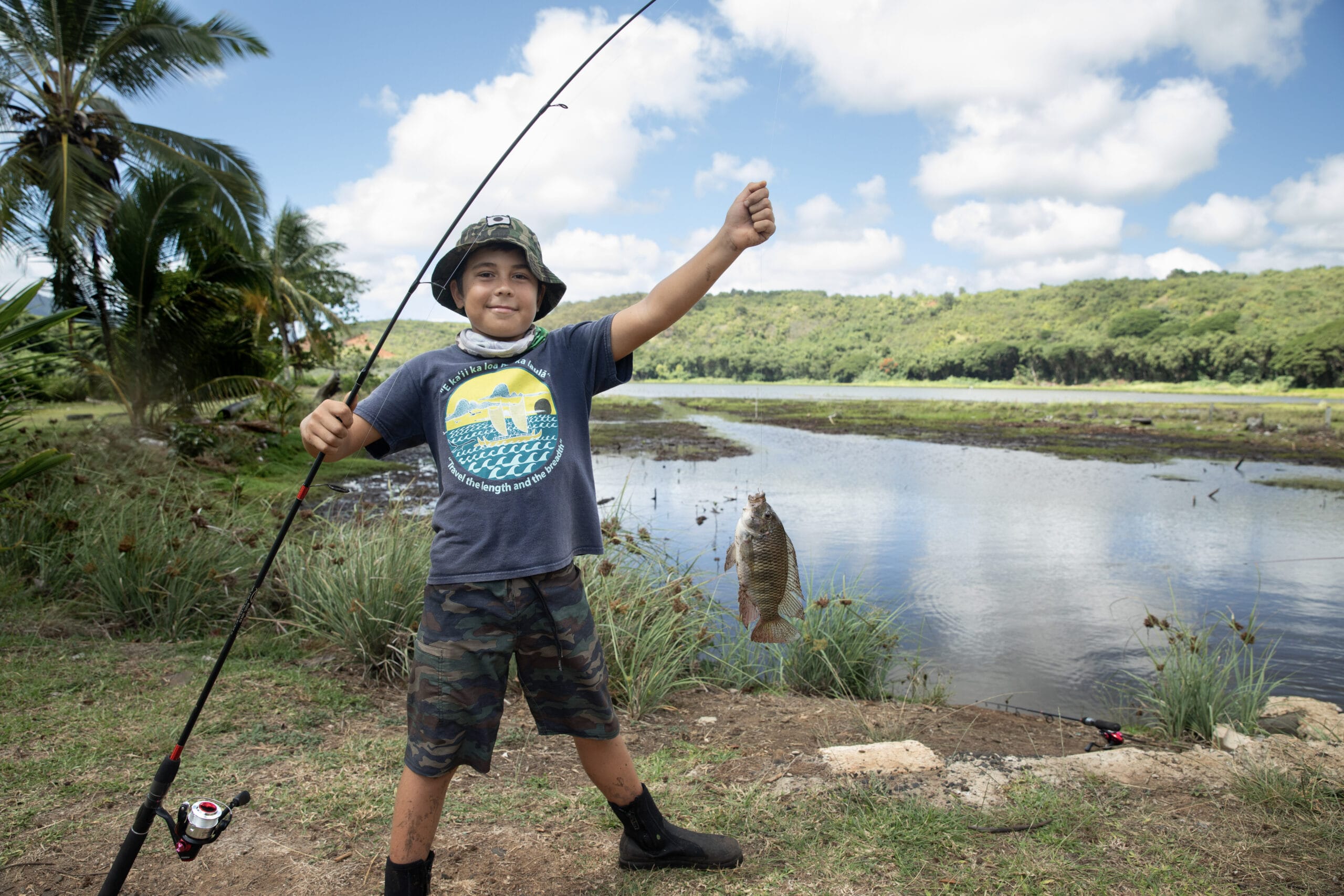 A boy holding up a fishing rod.
