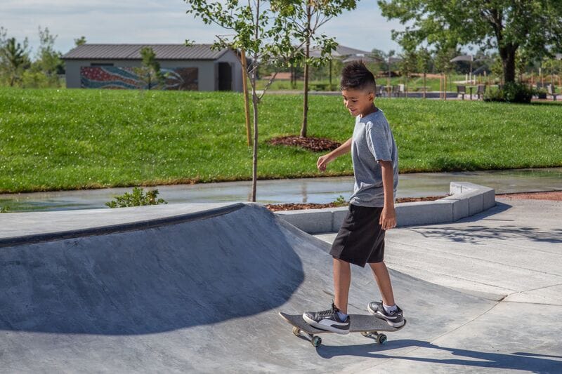 A young boy riding a skateboard in a park.
