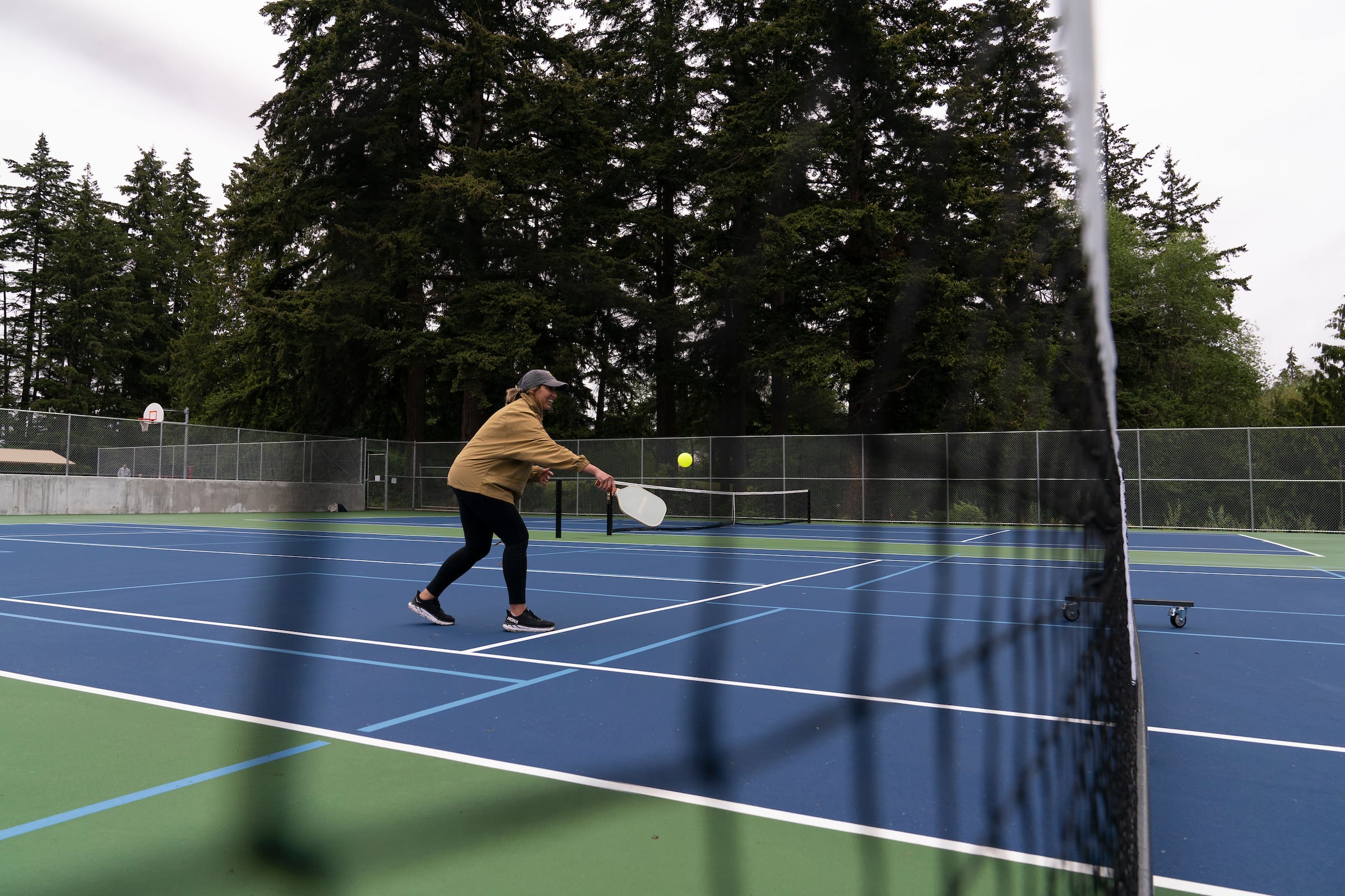 A woman is hitting a tennis ball on a tennis court.