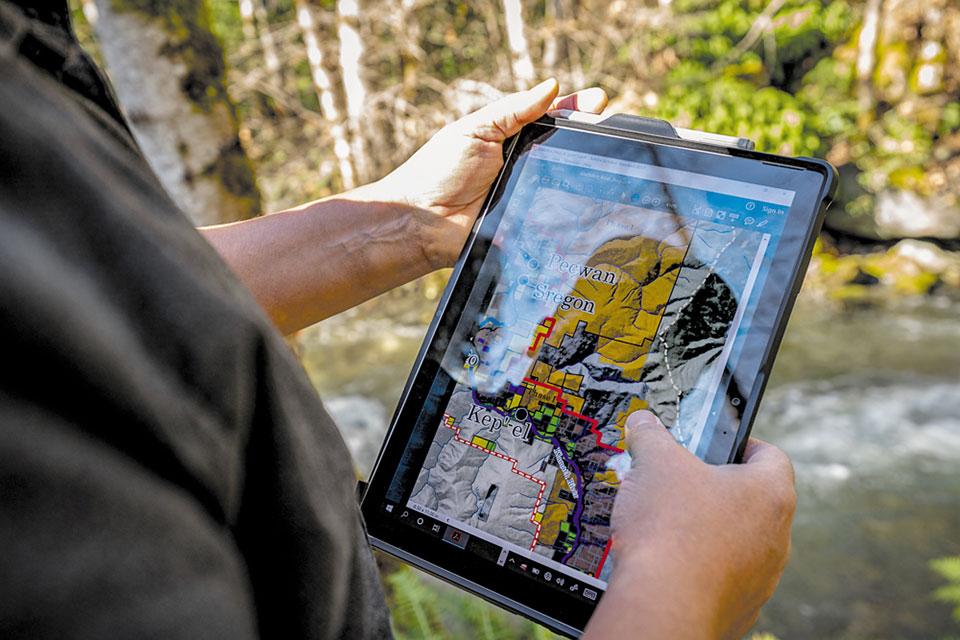 A person holding a tablet with a map on it.