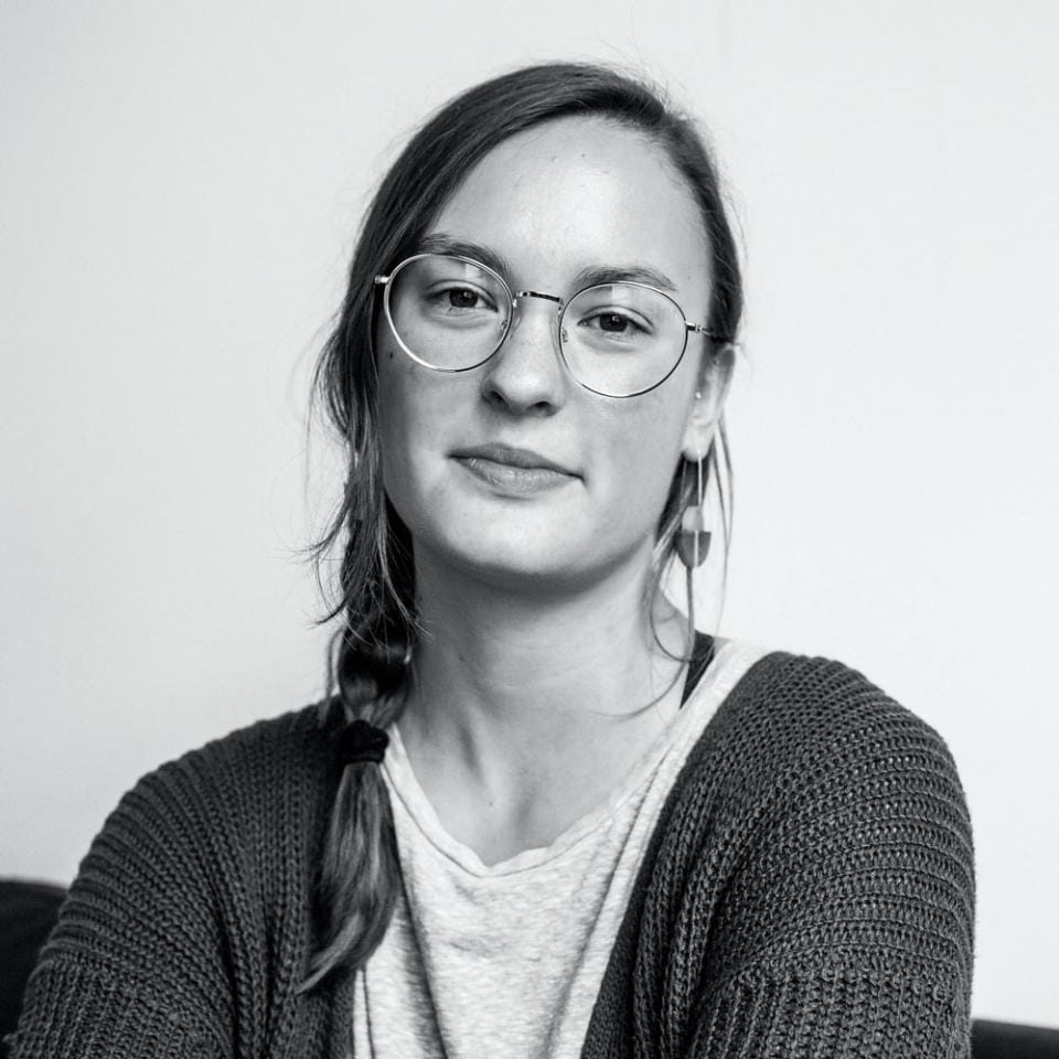 A black and white photo of a woman wearing glasses.