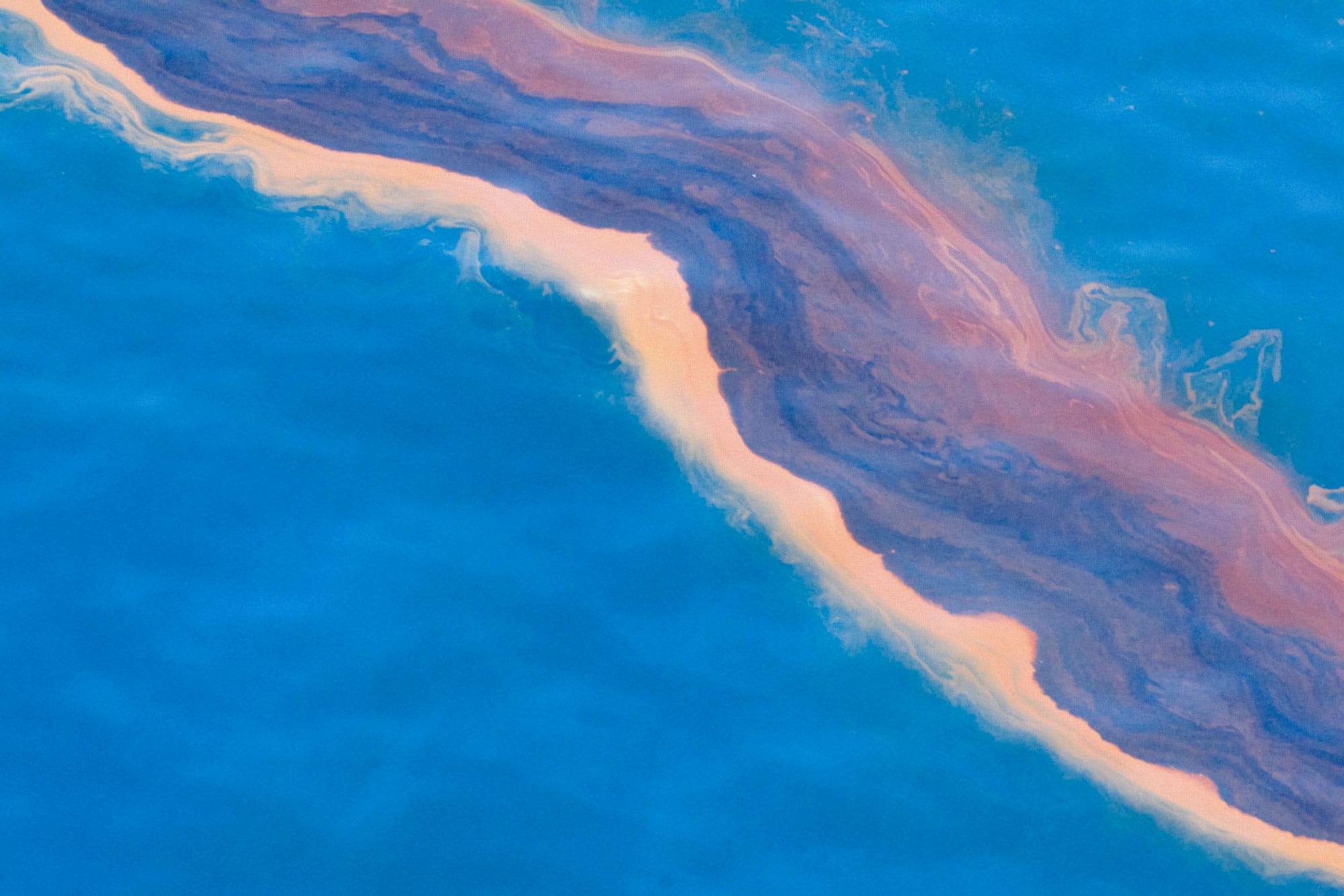An aerial view of a large amount of oil in the ocean.