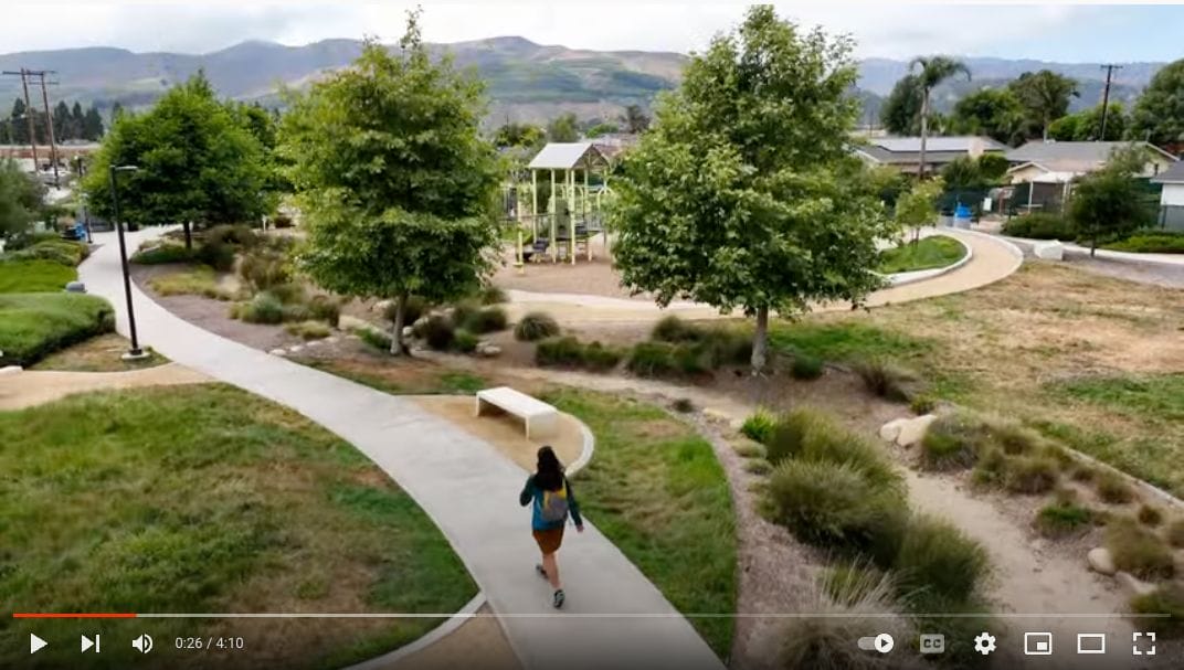 A video showing a person walking down a path in a park.