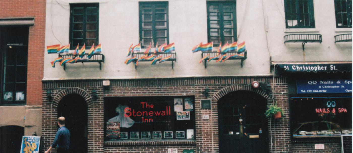 A brick building with a rainbow flag on it.