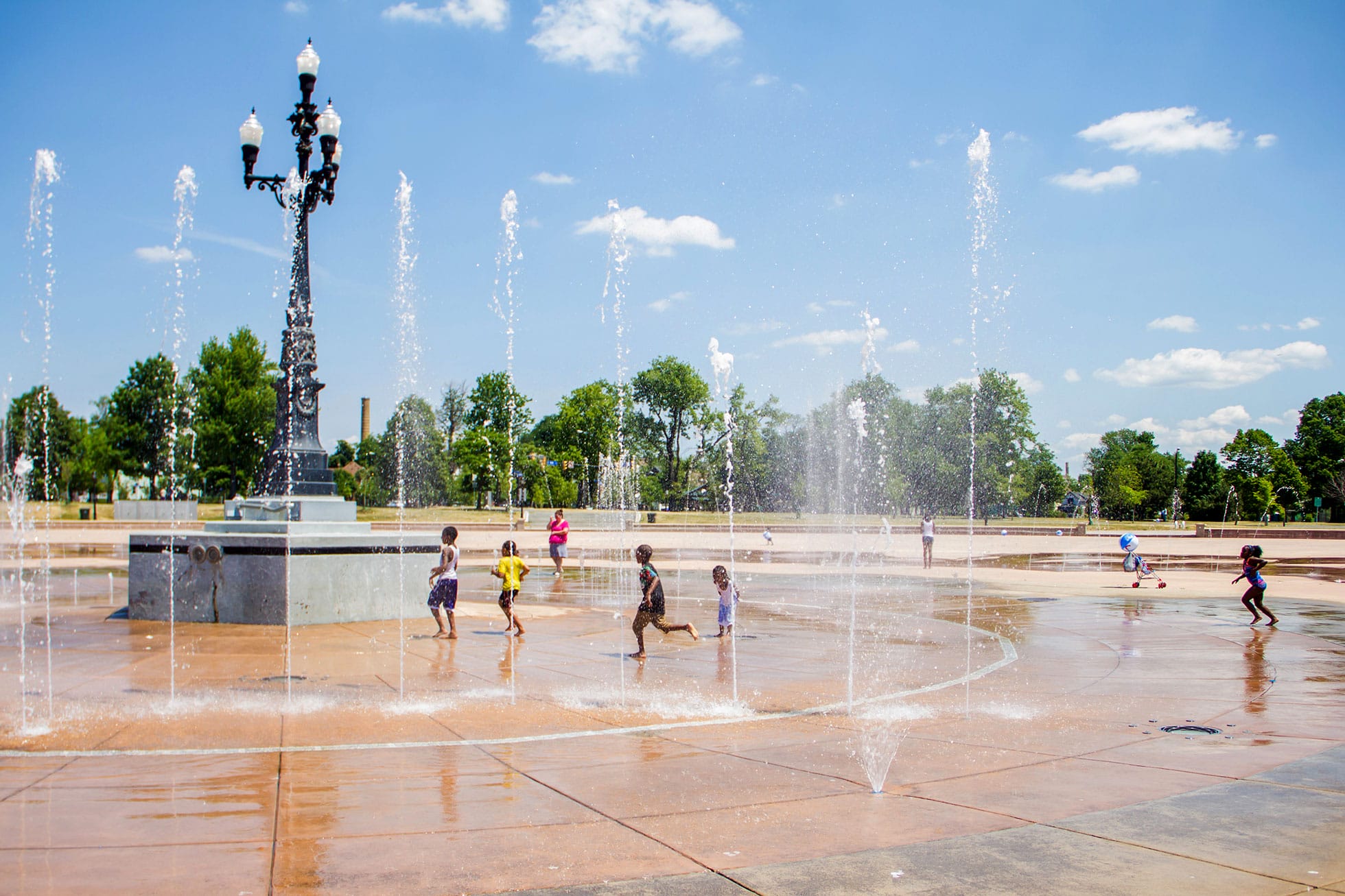 A group of children playing in a fountain.