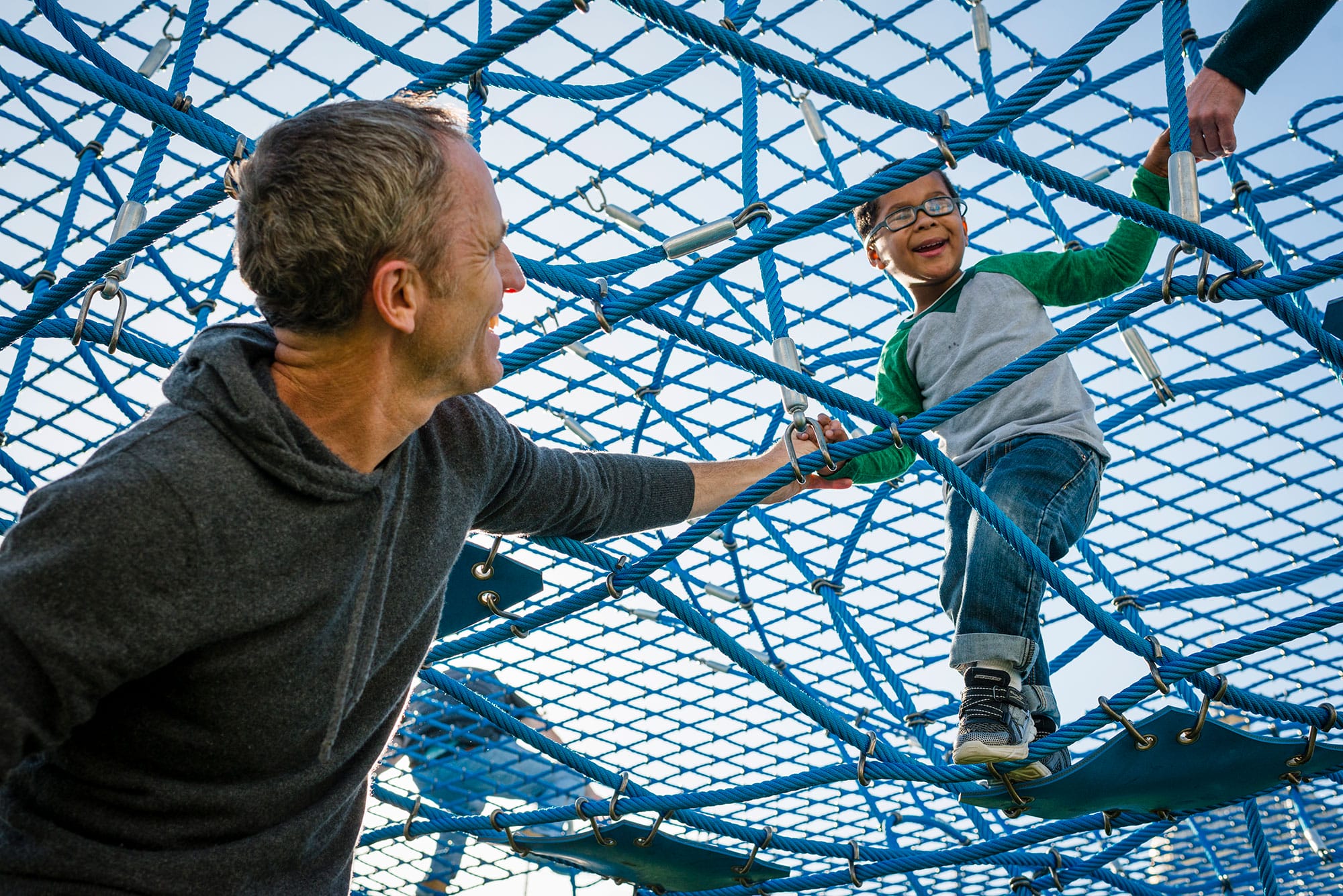 A man and a child playing on a playground.