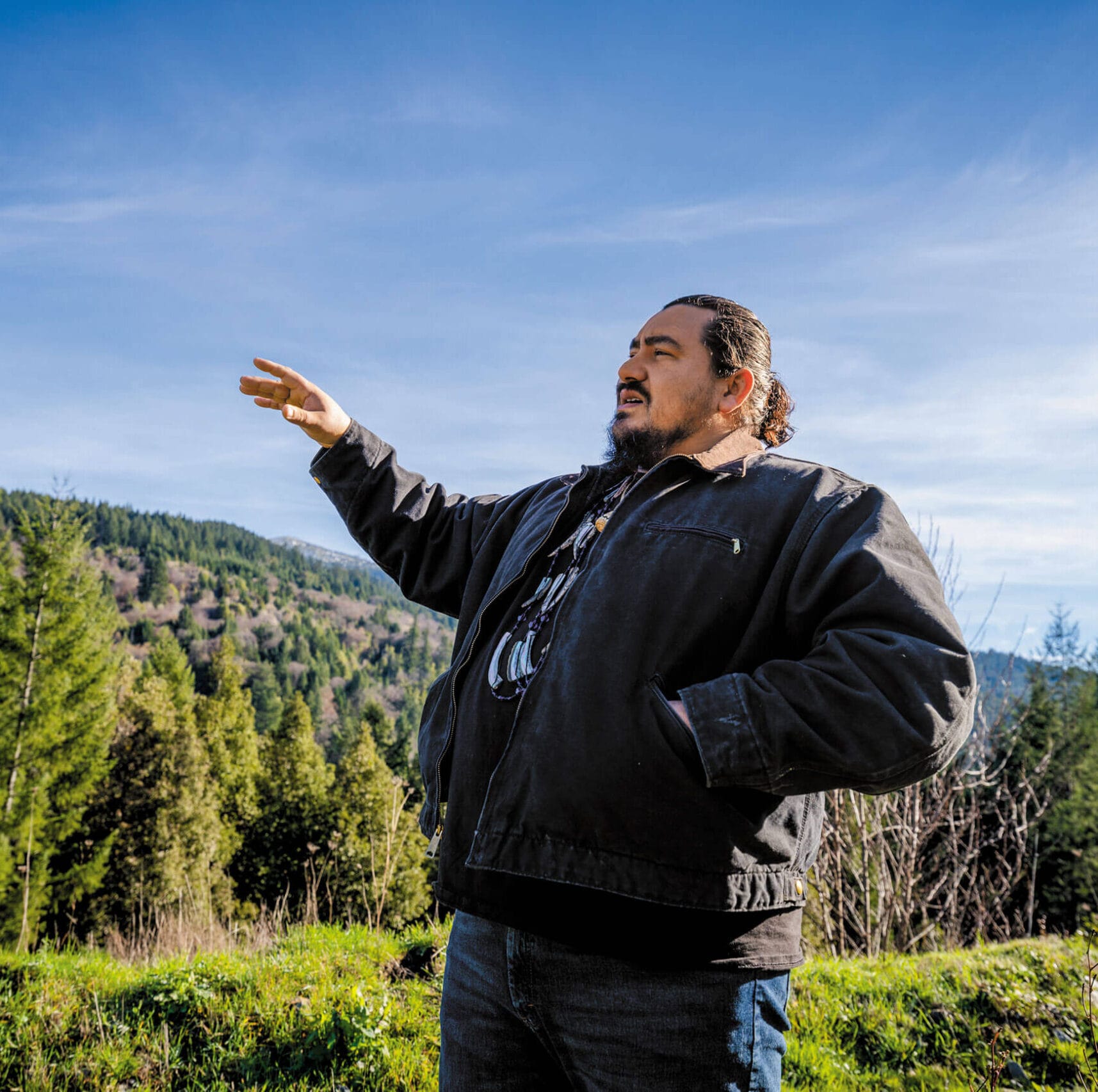 A man standing in a field with his arms outstretched.