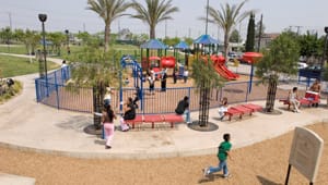 Children playing in a park with a playground.