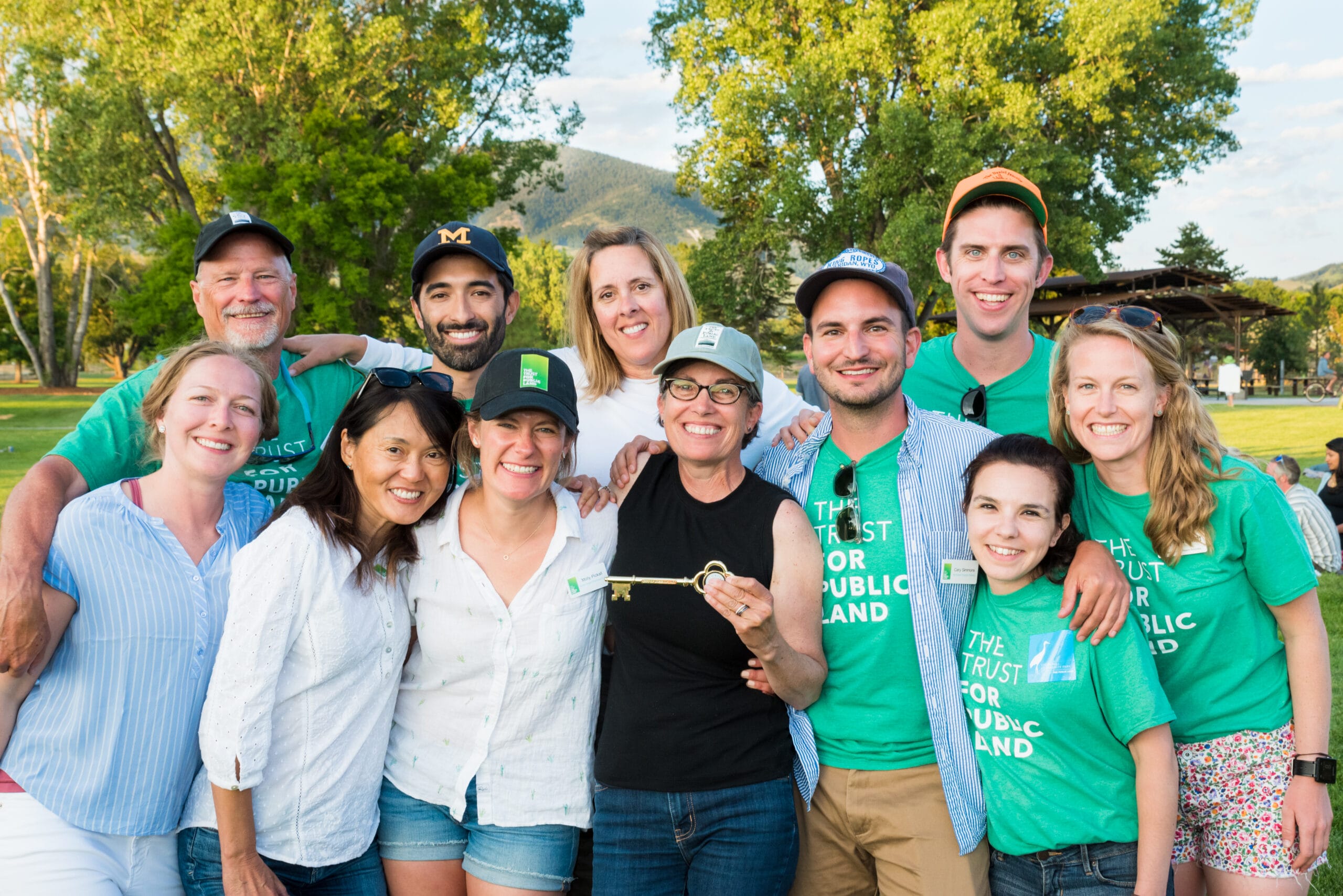 A group of people in green shirts posing for a photo.
