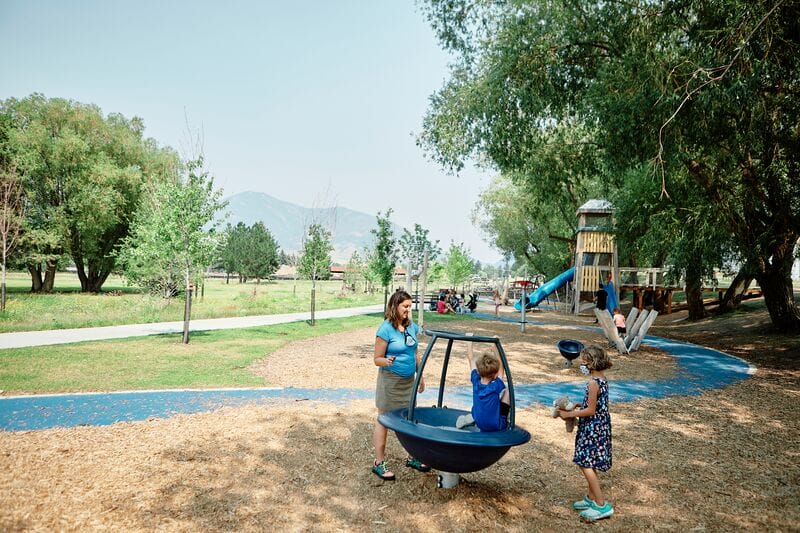 A group of children play in a playground at a park.
