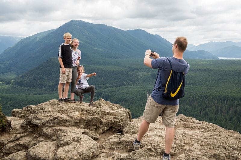 A group of people taking a picture on top of a mountain.