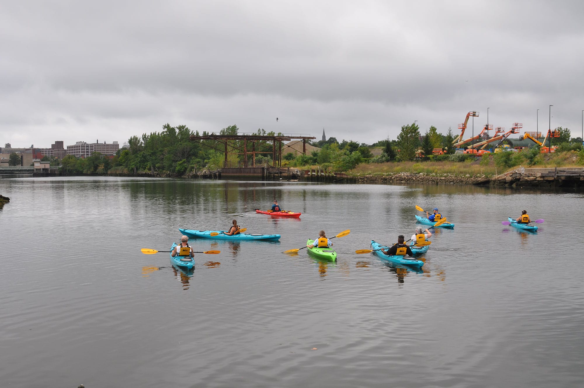 A group of people in kayaks on a body of water.