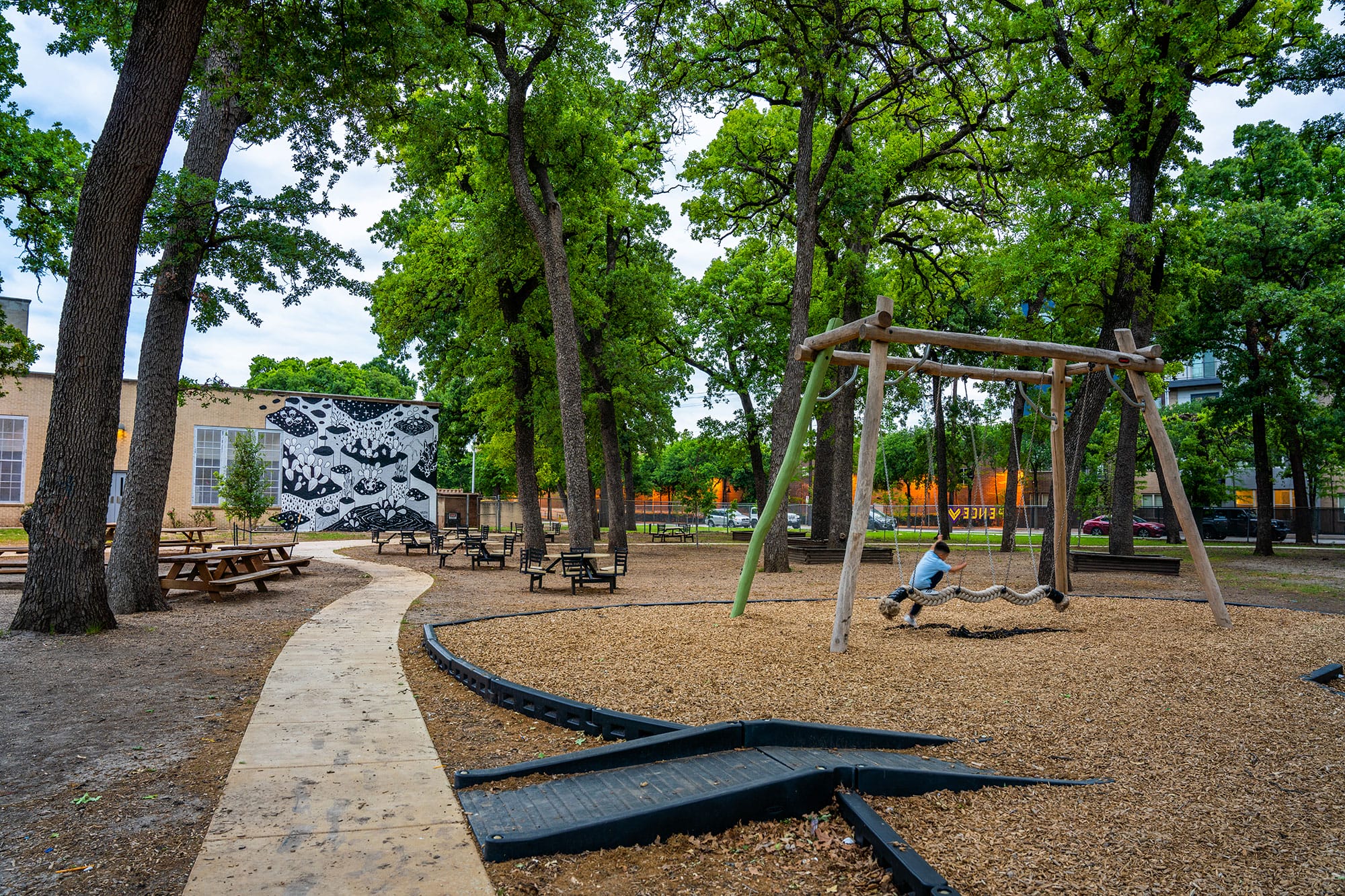 A playground with swings and benches.