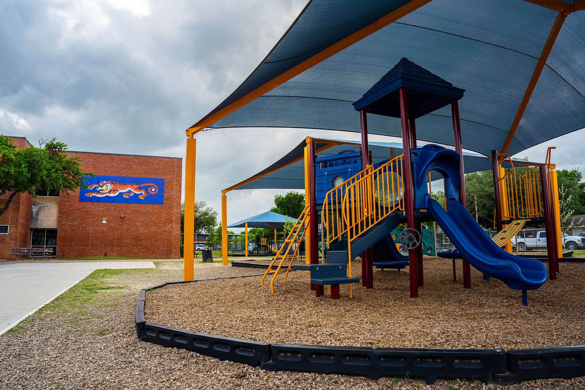 A playground with a slide and a canopy.
