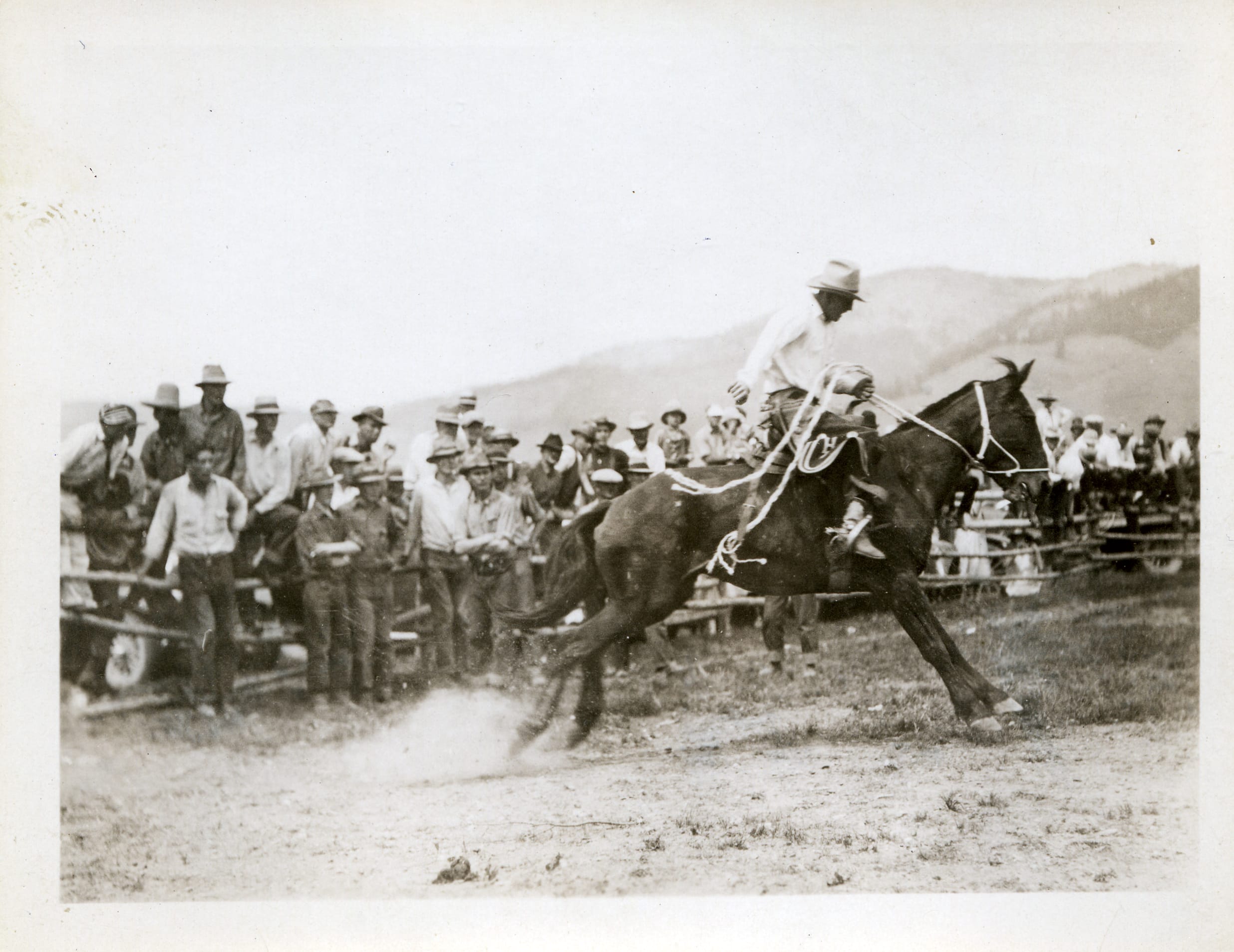 A man riding a horse in front of a crowd.