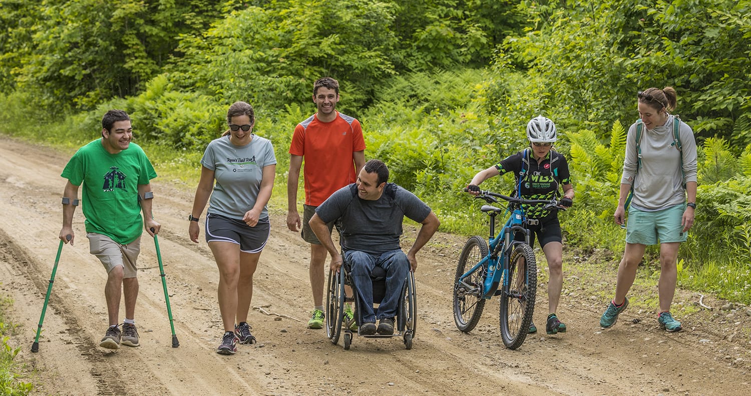 A group of people riding bikes on a dirt road.