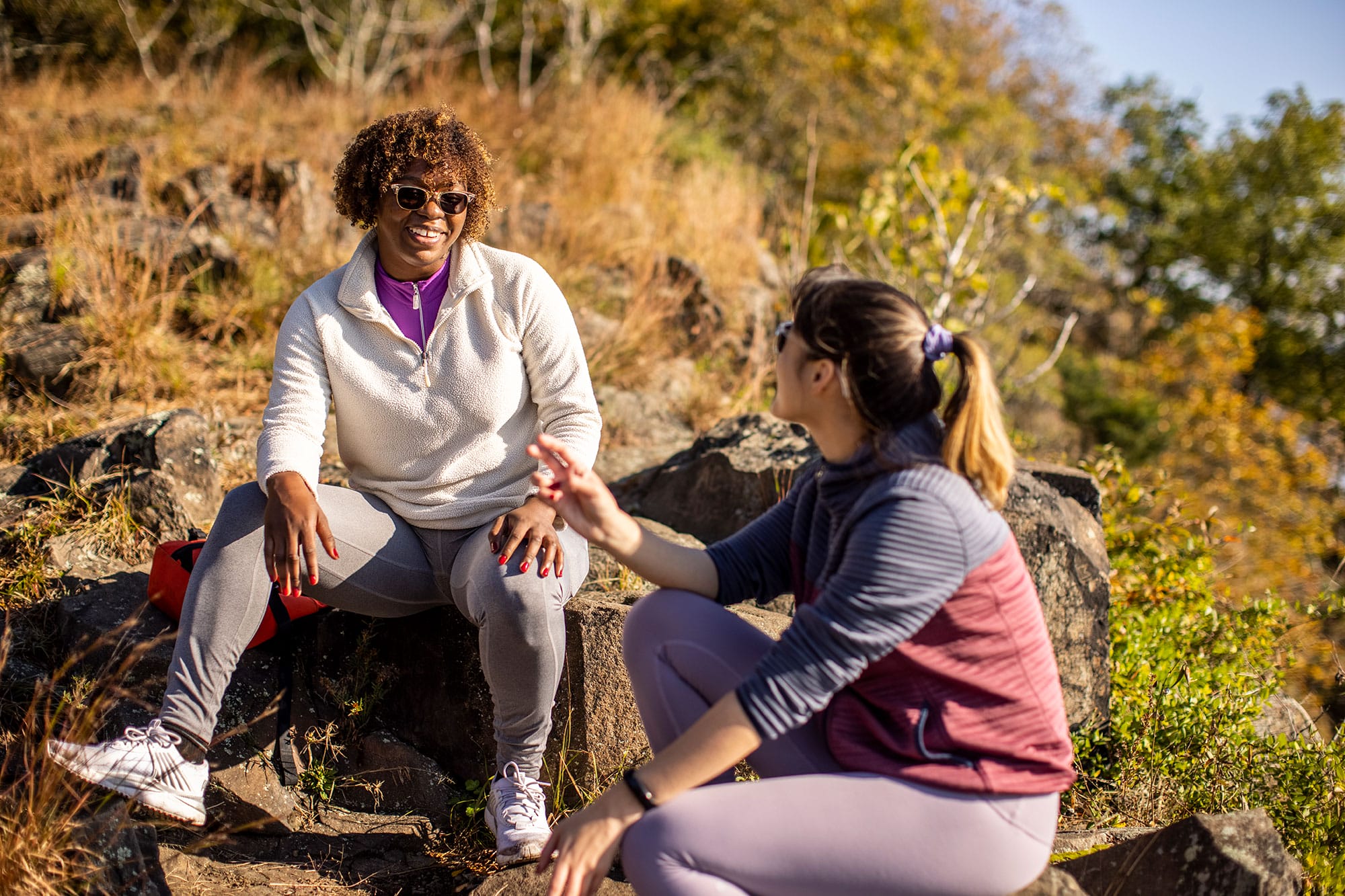 Two women talking on a rocky trail.
