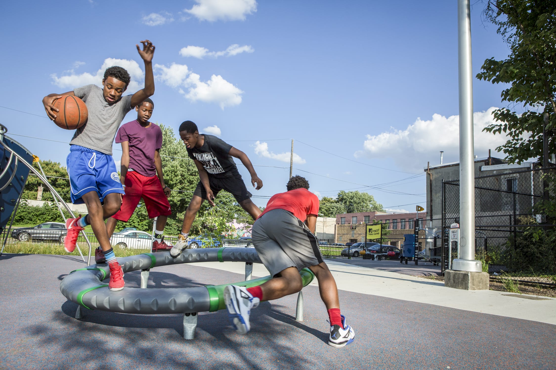 A group of young men playing basketball on a trampoline.