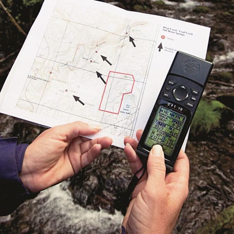 A person holding a gps device and a map.