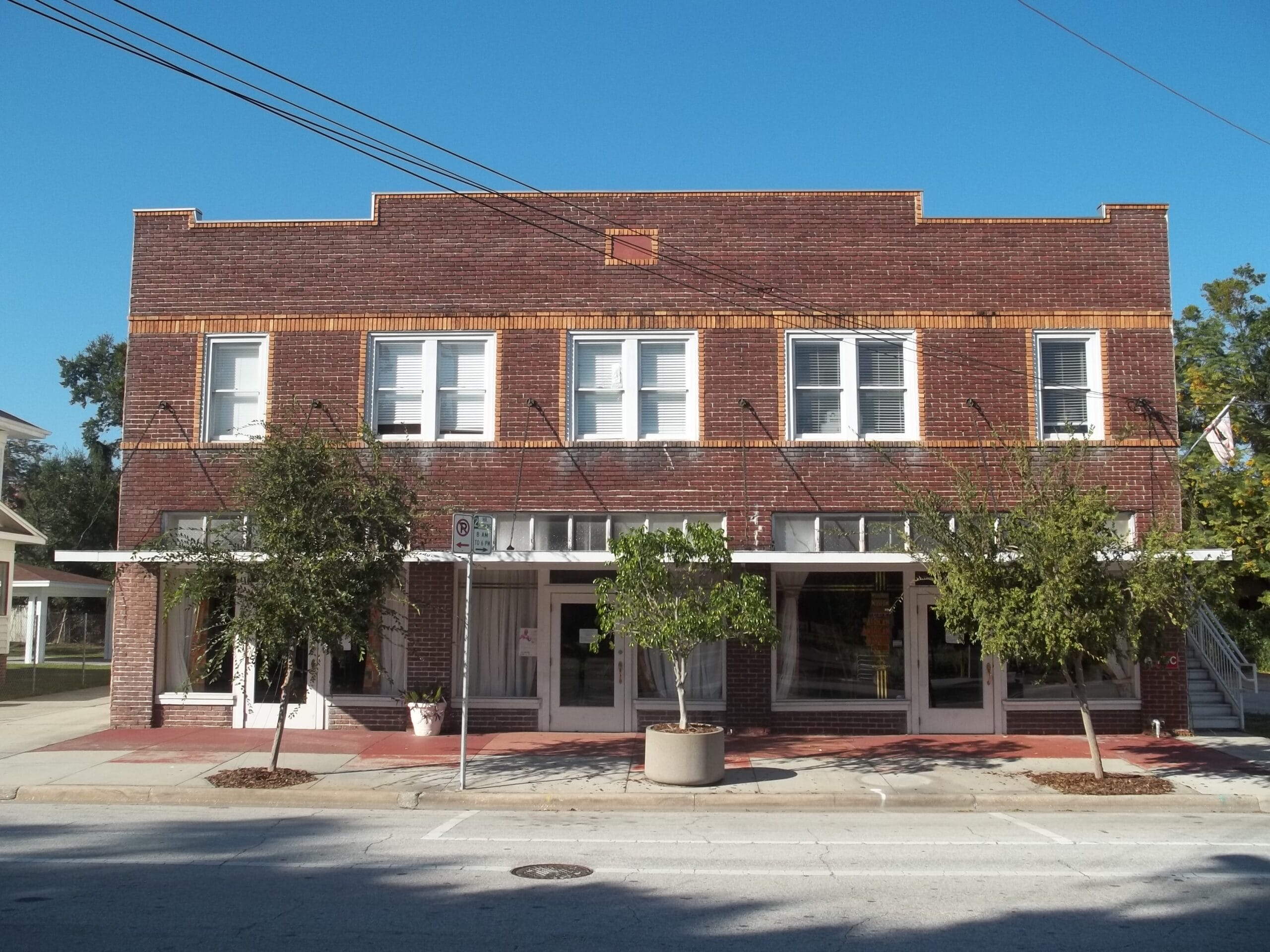 A brick building with many windows on a sunny day with blue sky above