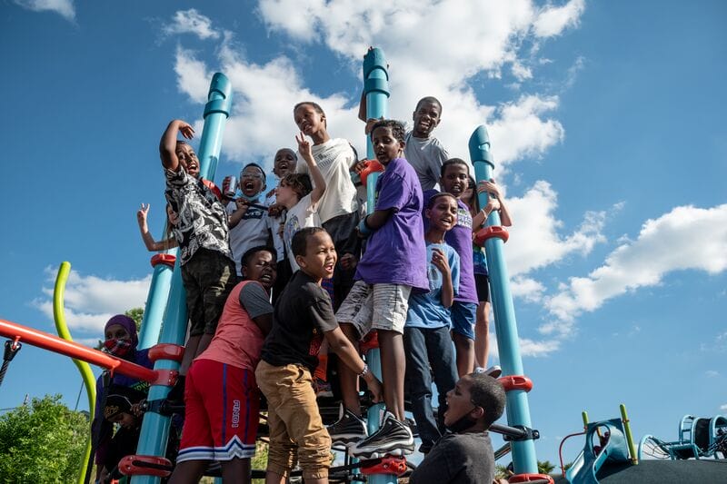A group of children standing on top of a playground structure.