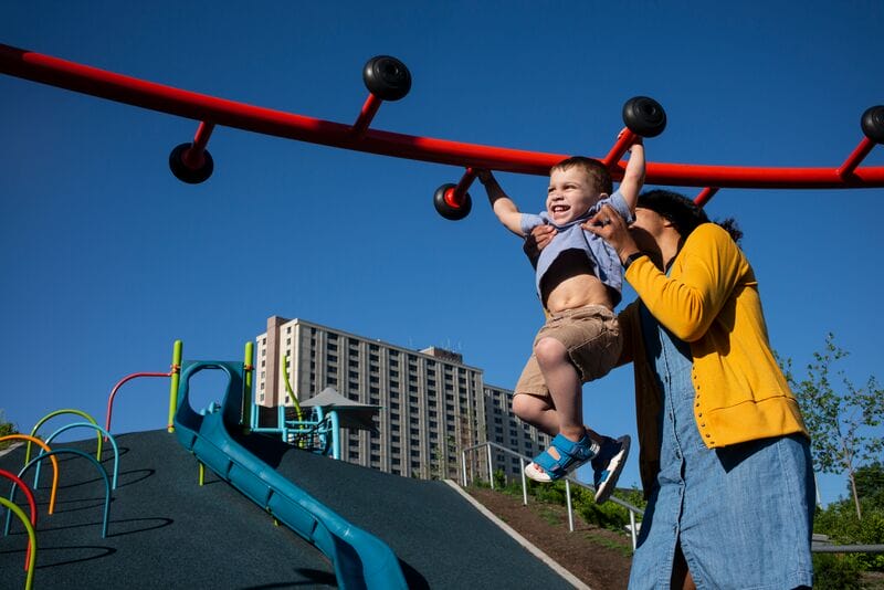 A woman and a child play on a playground.