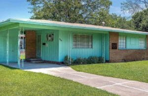 A house with a green door and a green lawn.