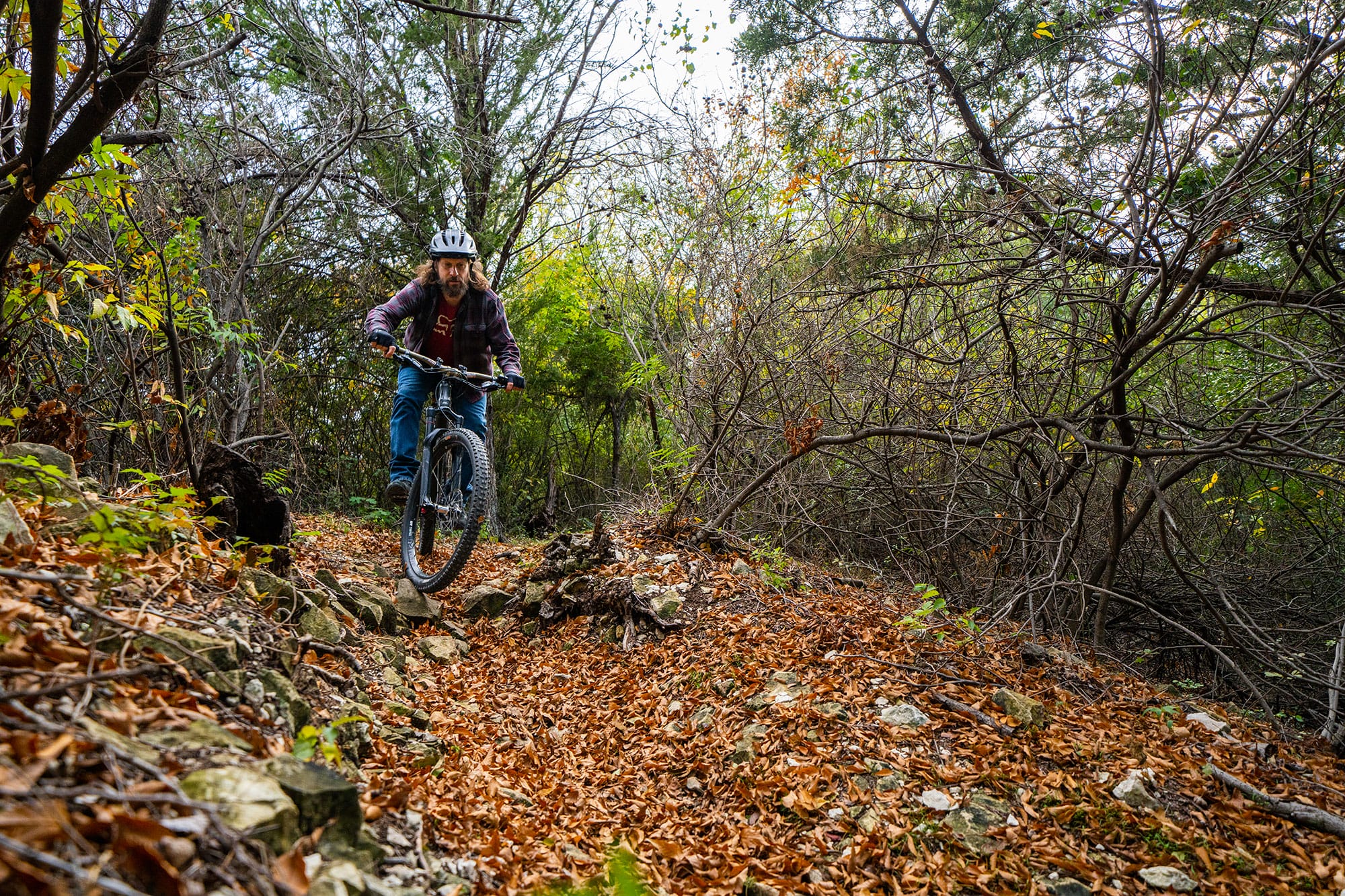 A person riding a mountain bike in the woods.