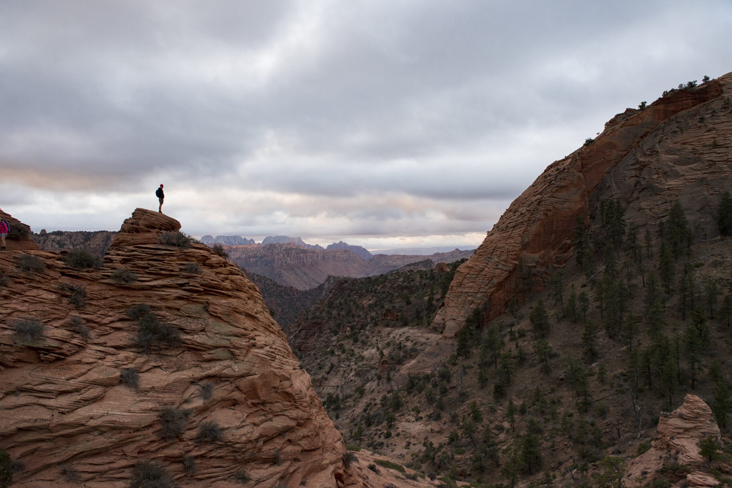 A person standing on top of a rocky cliff.