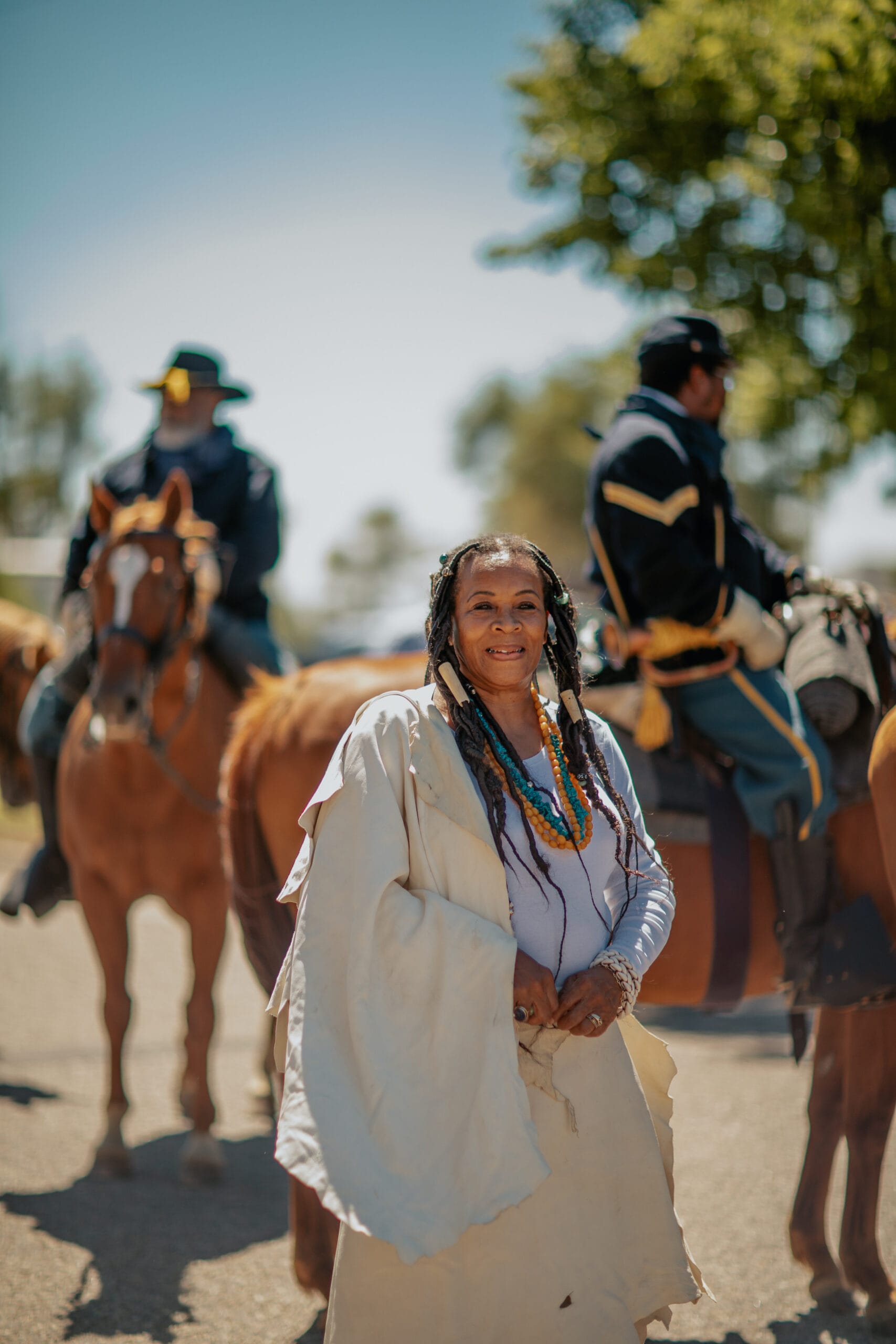 A woman is standing next to a group of horses.