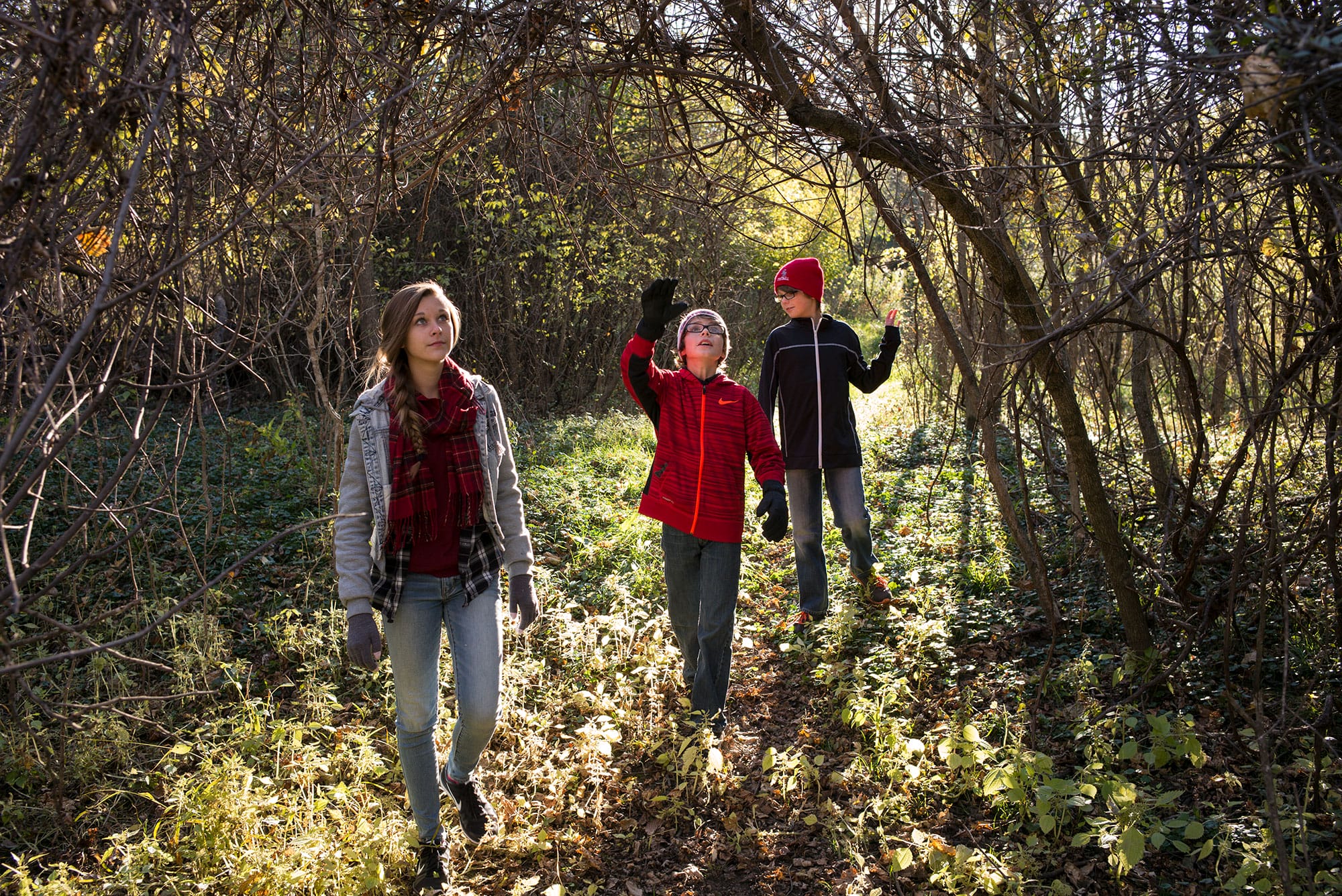 A group of people walking through a wooded area.
