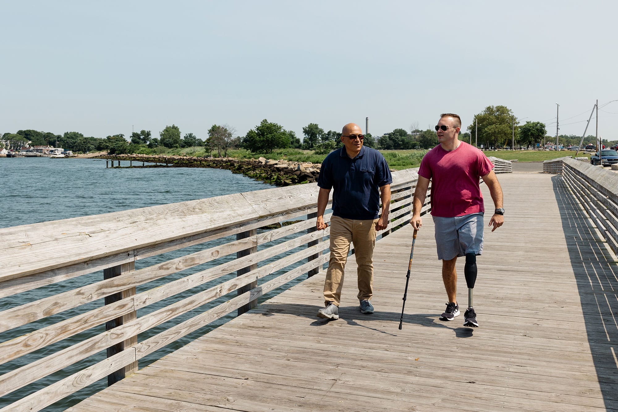 Mariano Rodriguez (left) and Collin McSpirit stroll on the boardwalk in Bridgeport, Connecticut’s Seaside Park. At a time when Americans expressfeelings of loneliness, isolation, and disconnection from neighbors, shared public spaces are important in helping people form and maintain relationships. Photo: Kristyn Miller