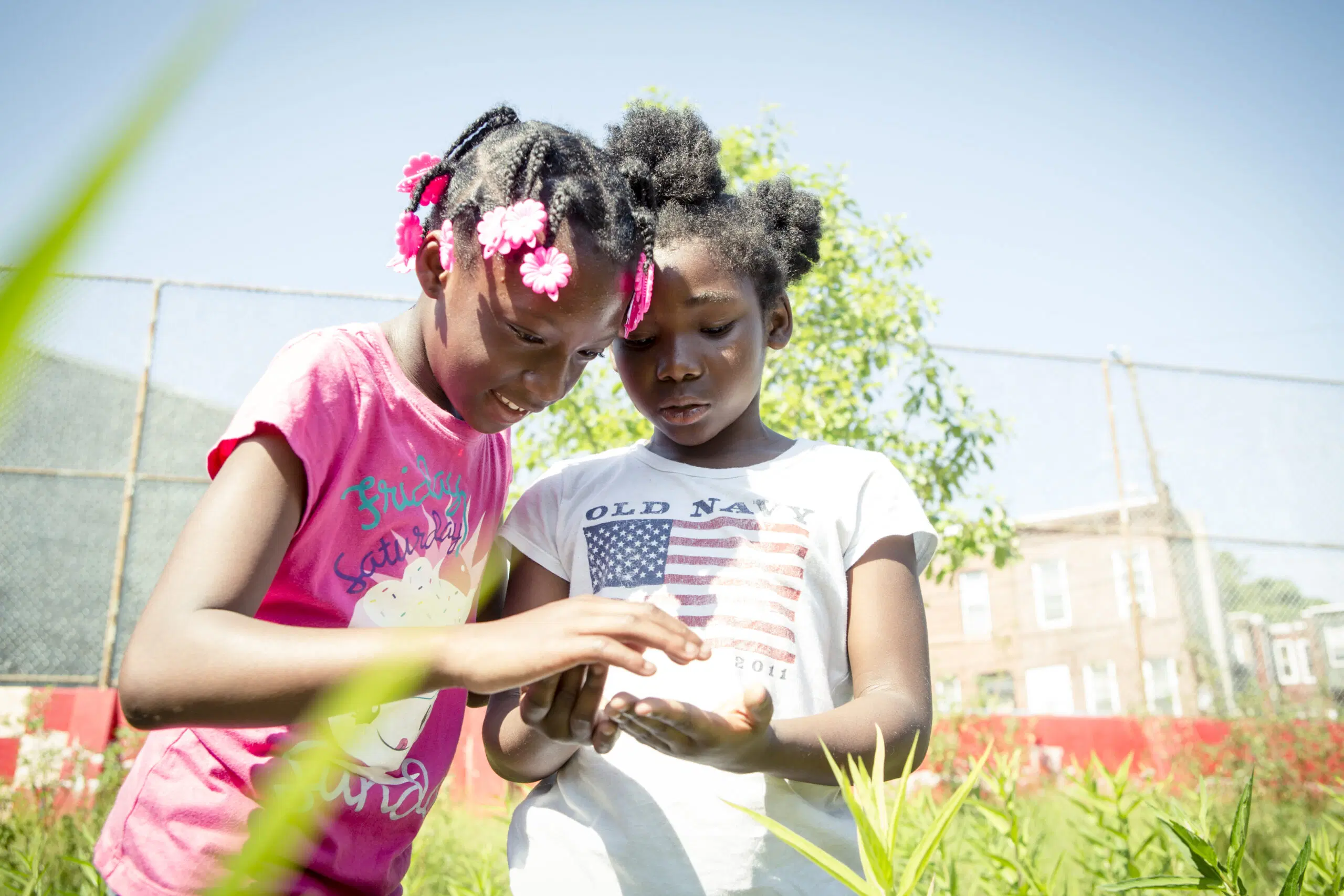 Two girls play and explore the outdoors at William Dick Schoolyard in Philadelphia.